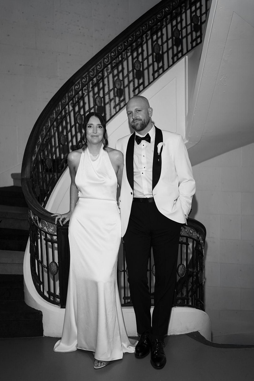 Black-and-white portrait of Meghan and Kevin on a curved staircase