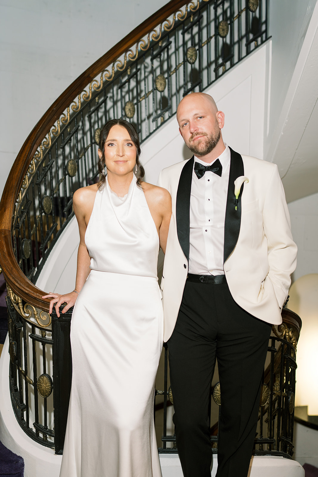 Meghan and Kevin posing together on a curved staircase