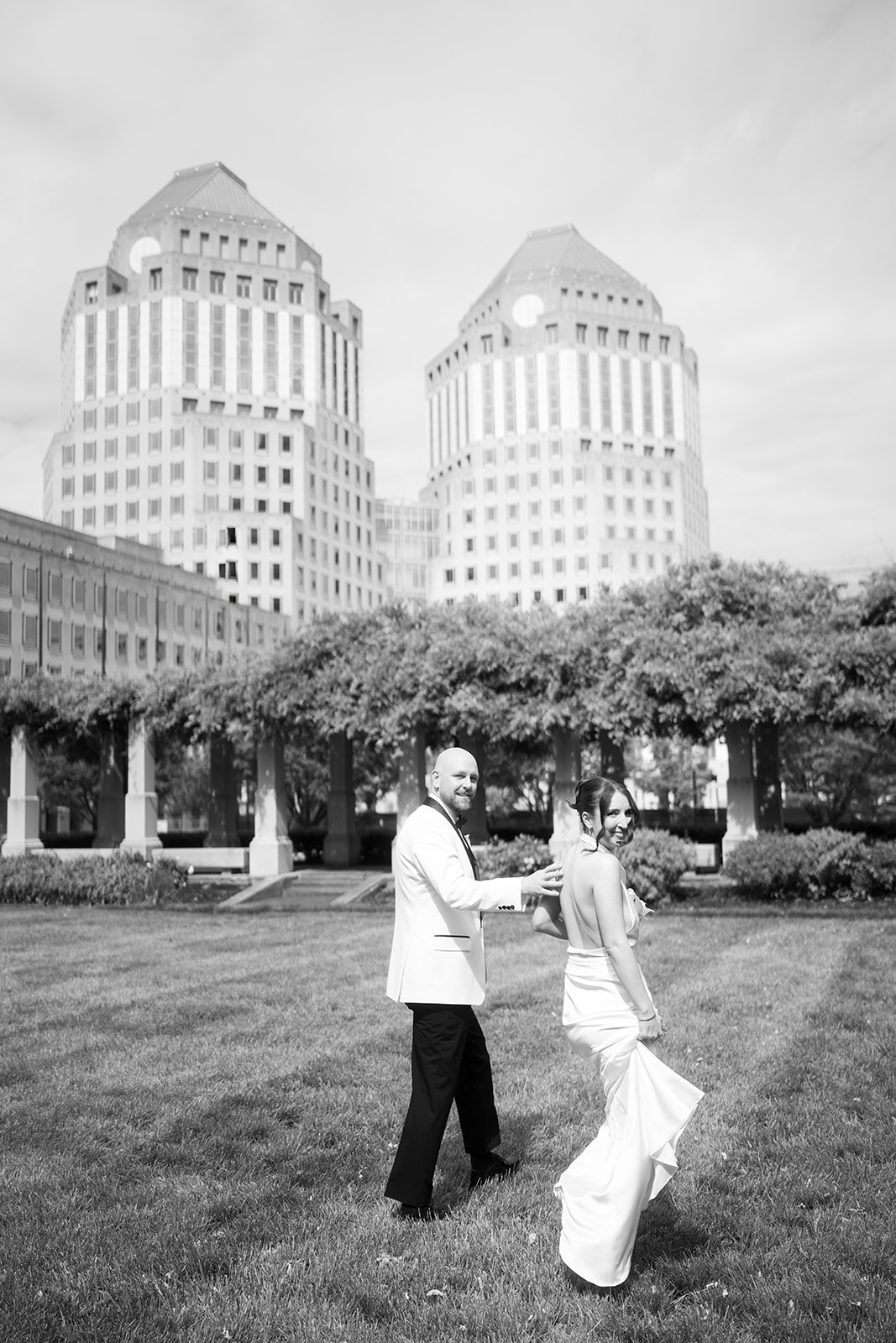 Meghan and Kevin walking together with the downtown Cincinnati skyline behind them