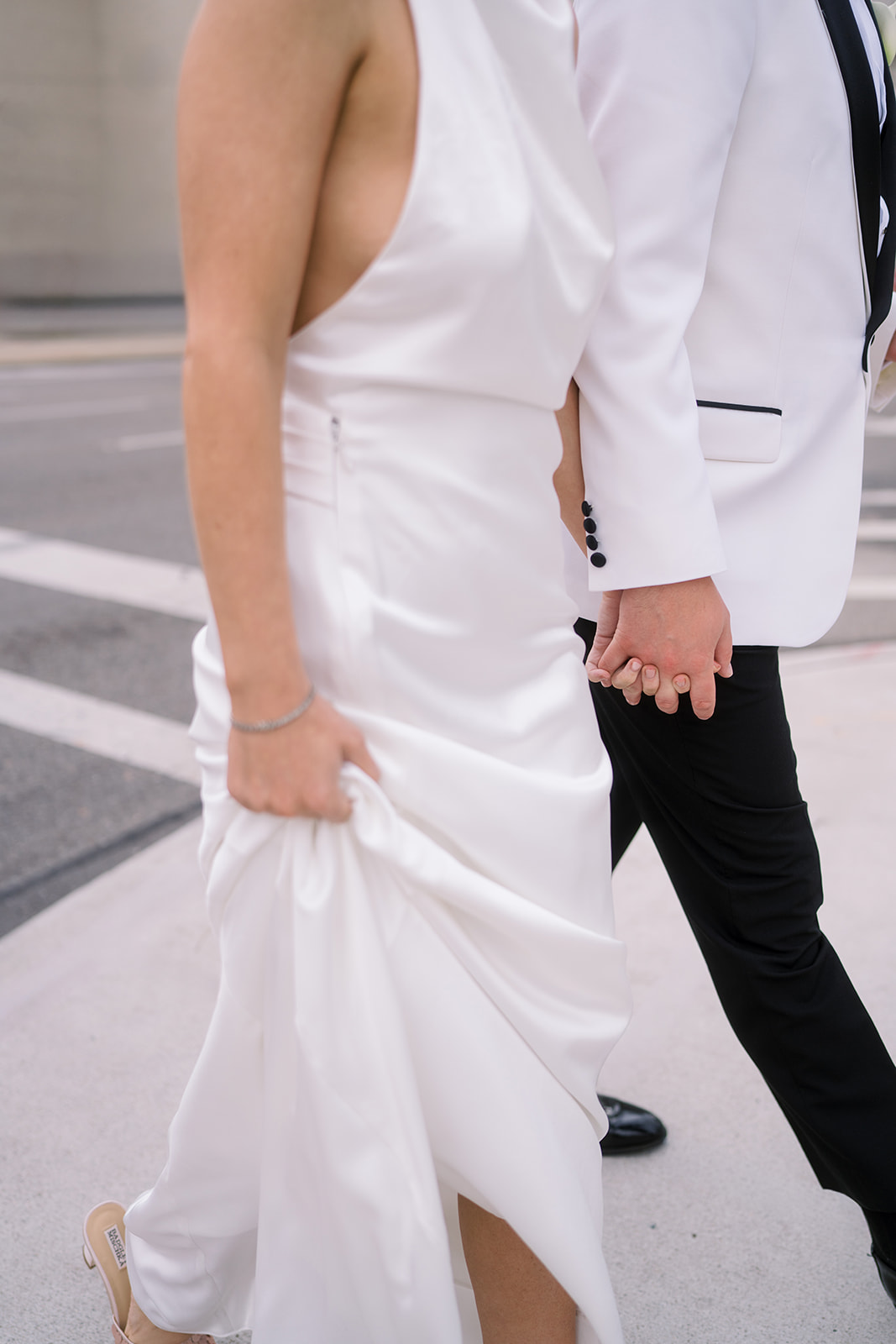 Close wedding-day detail of Meghan and Kevin holding hands