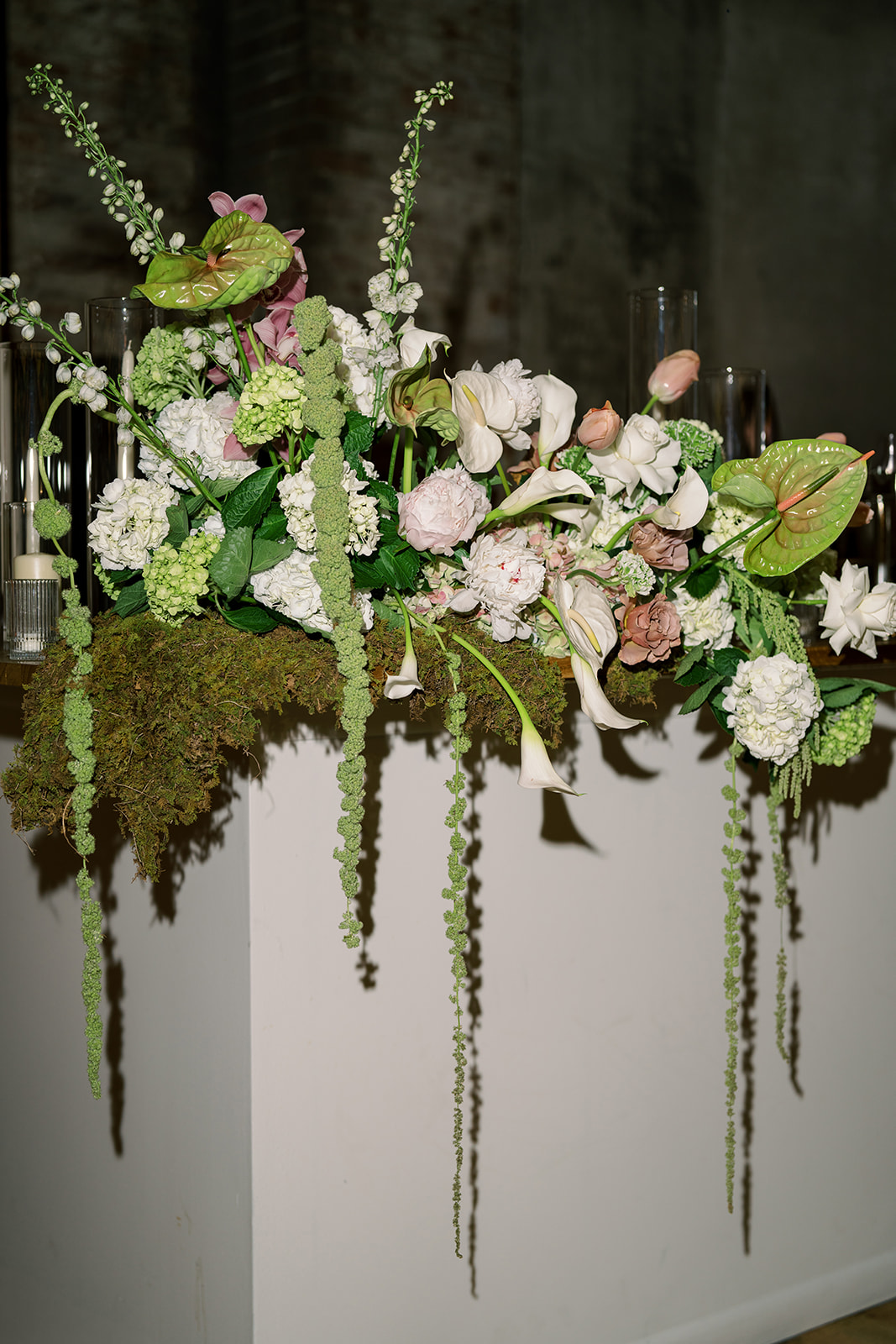 Large pink, white and green floral installation above the reception bar