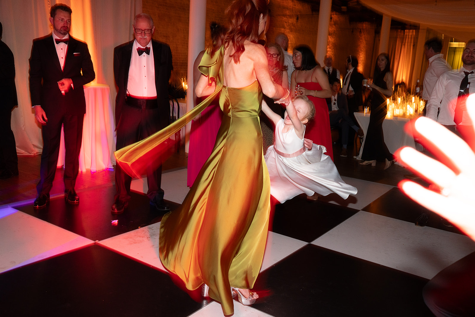 Wedding guest in a green dress dancing during the live-band reception
