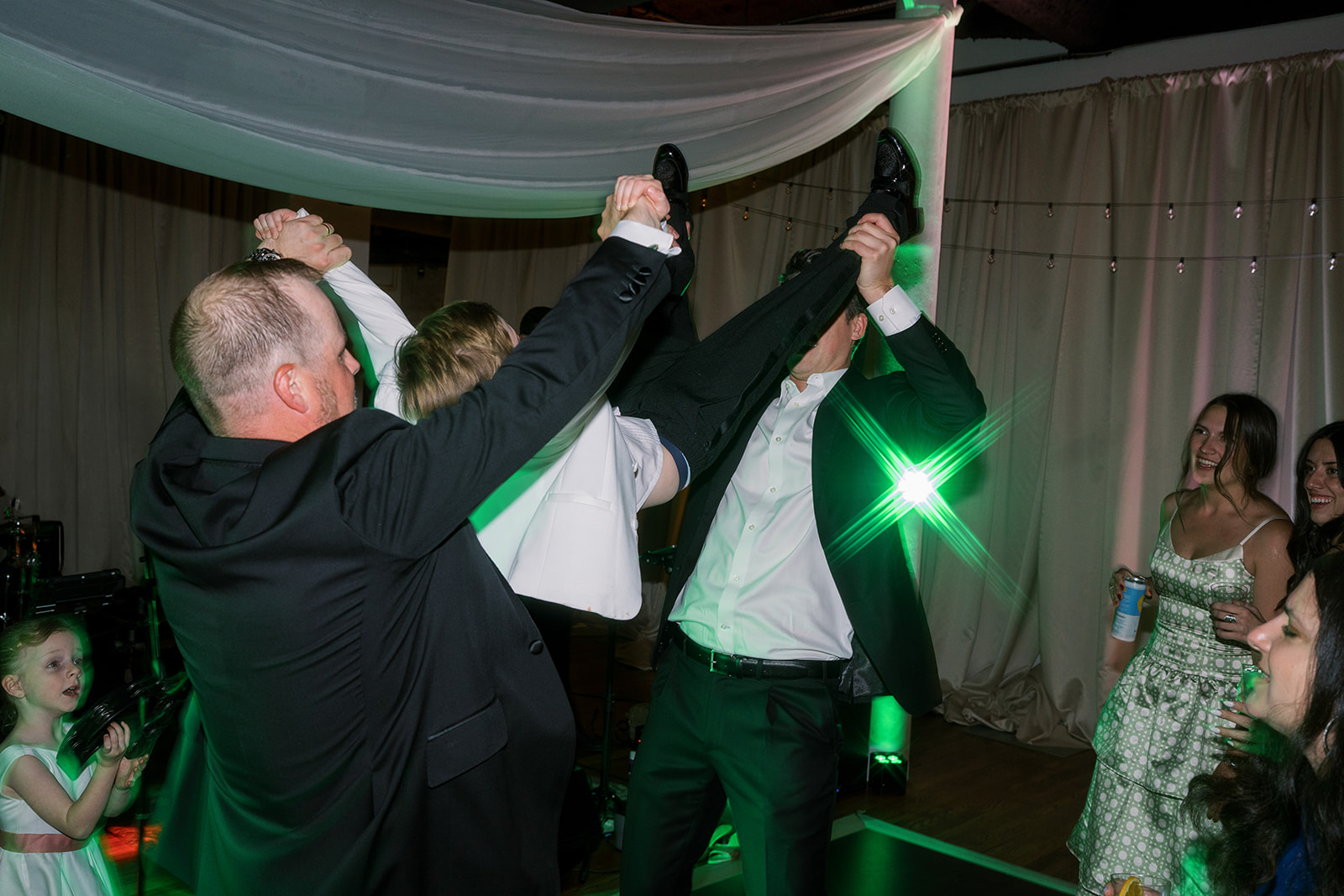 Wedding guests raising their drinks together on the dance floor
