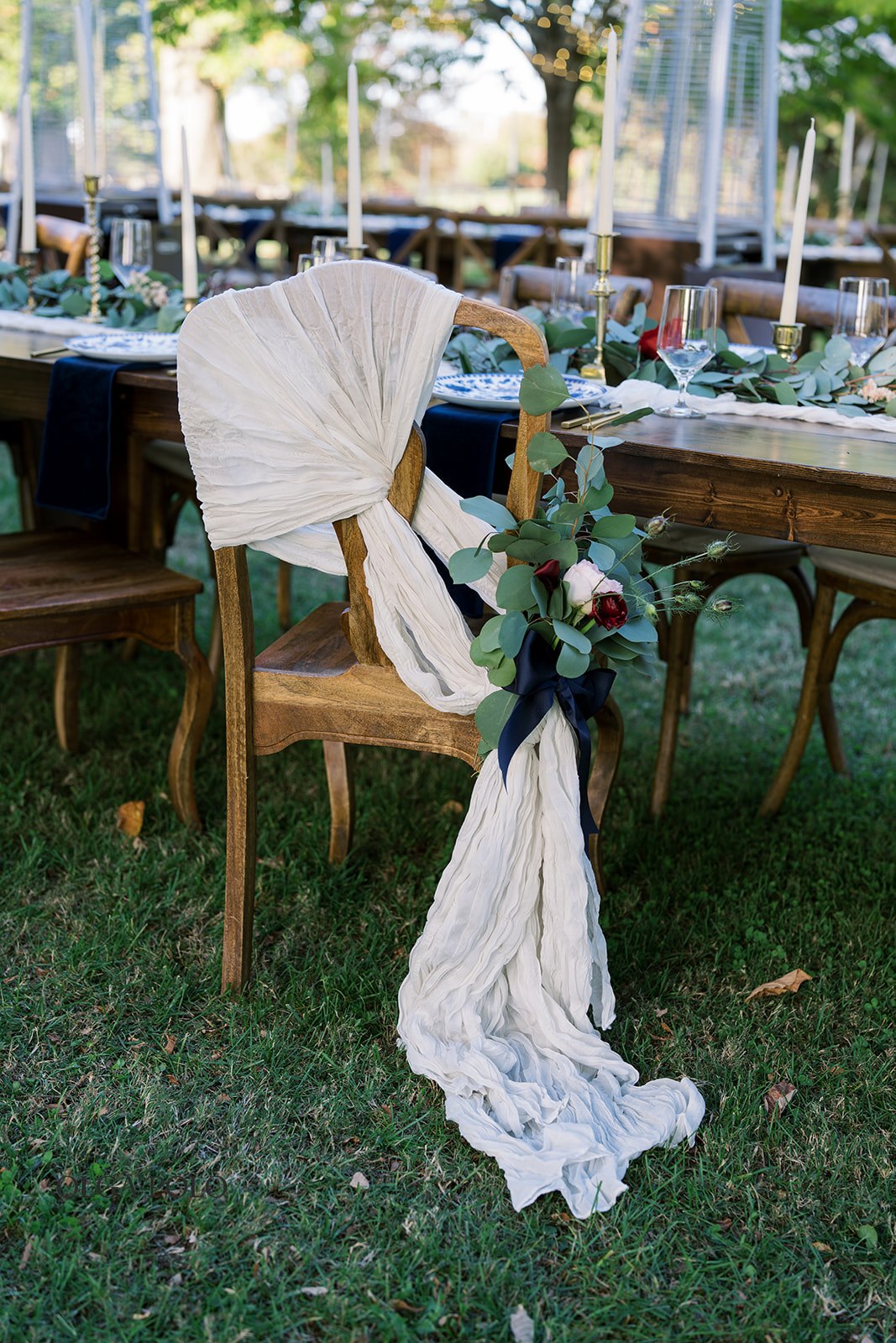 Beth holding her bouquet beside a decorated outdoor reception table
