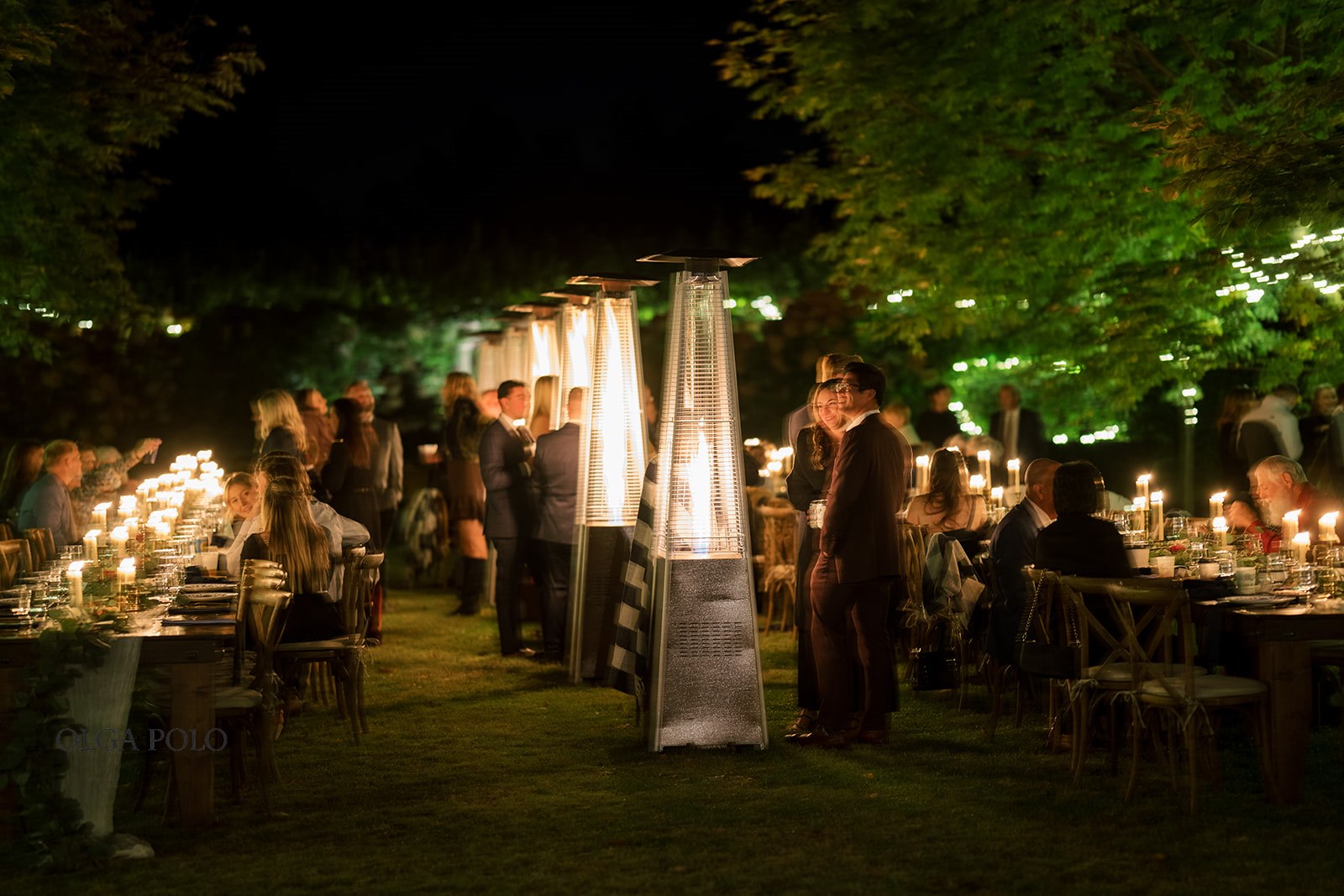 Wide evening view of the candlelit outdoor reception at Heartland of Versailles