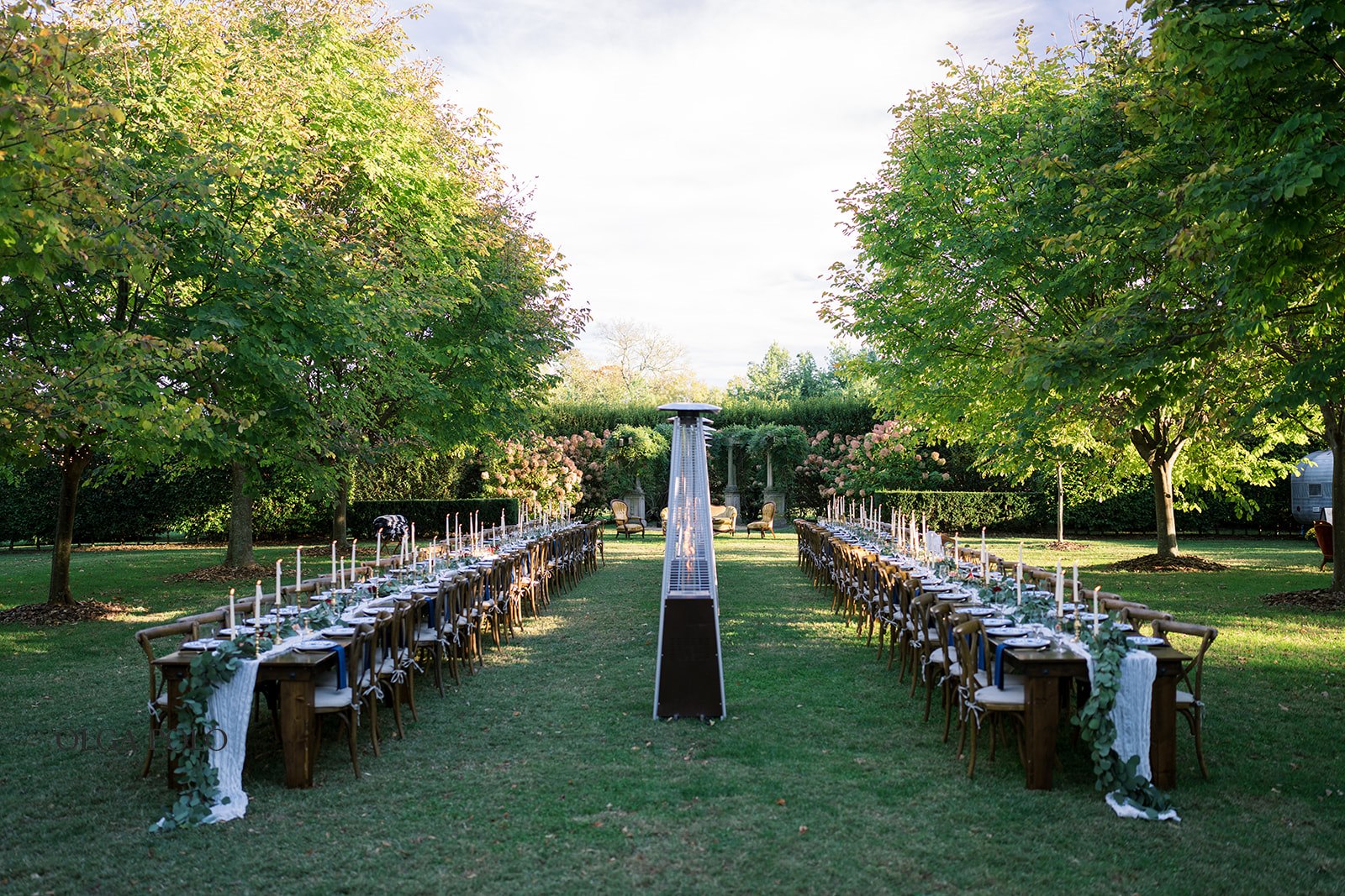 Long wedding tables arranged on the lawn at Heartland of Versailles before dinner
