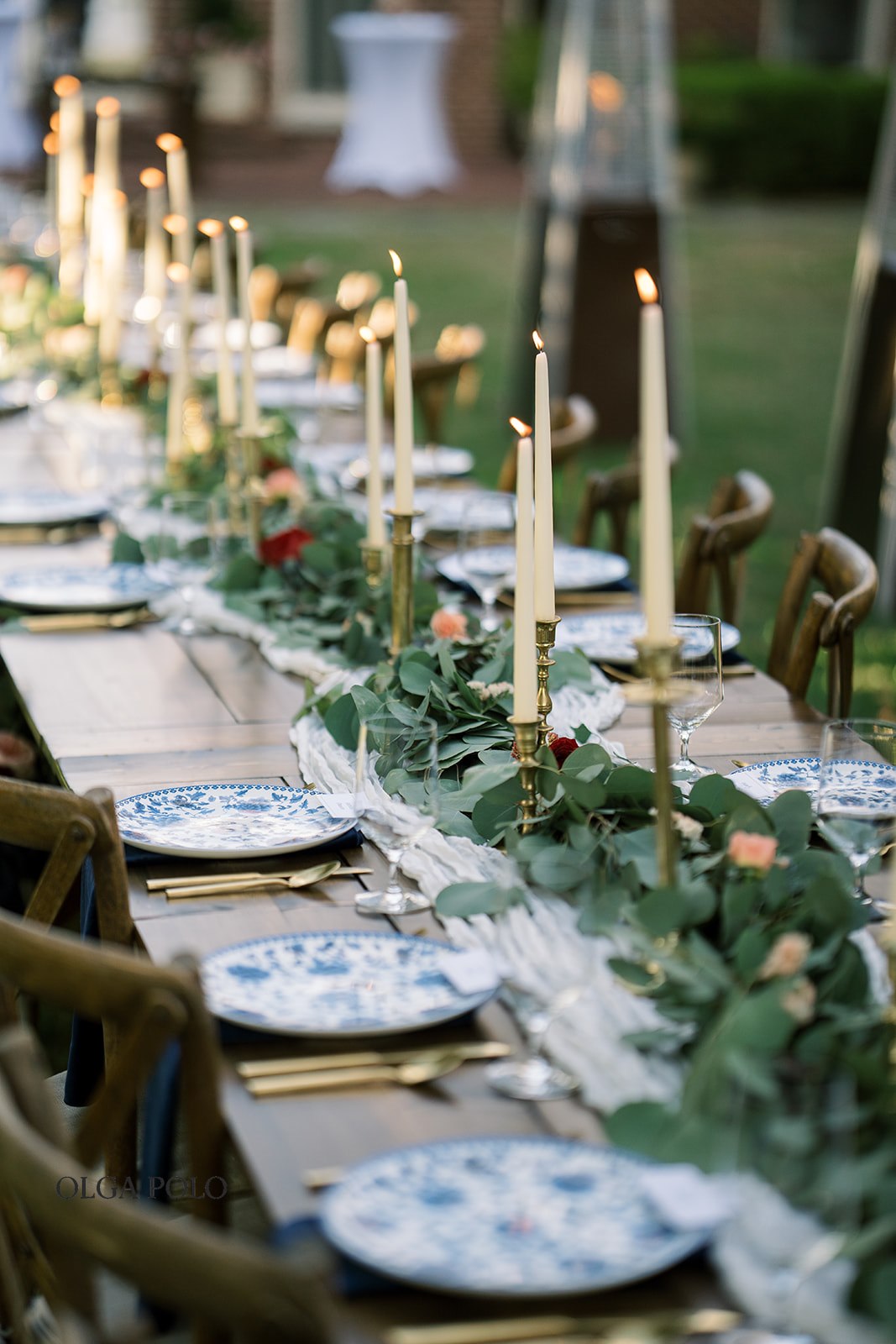 Blue-and-white place setting with greenery and candlelight at the Heartland reception