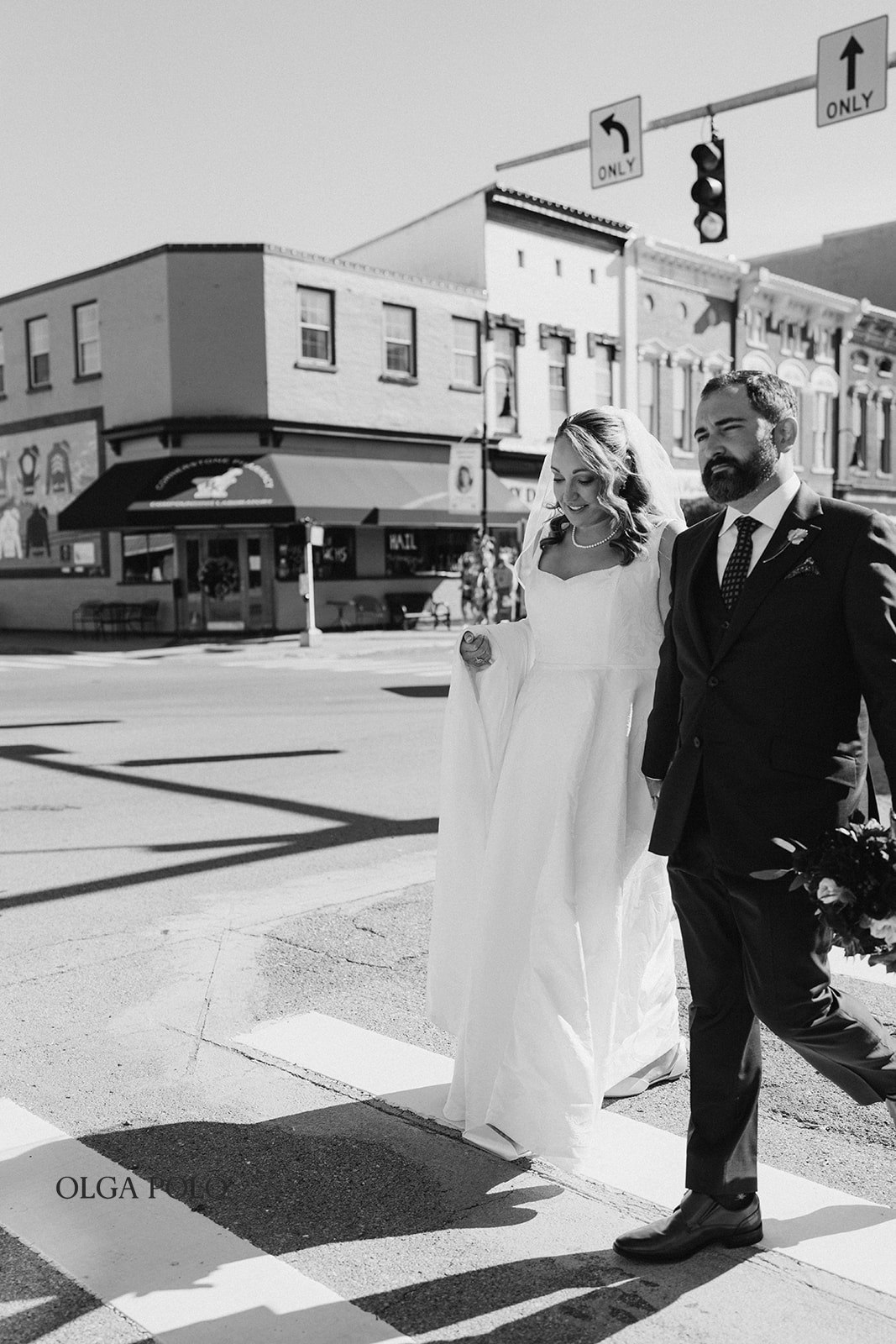 Black-and-white portrait of Ryan and Beth walking together in downtown Versailles