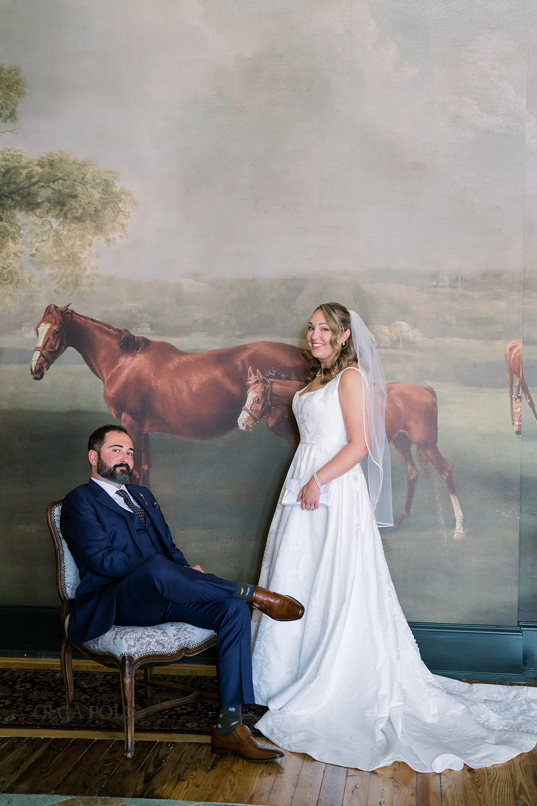 Ryan and Beth posing together beside horse artwork at The Aldenberg Hotel