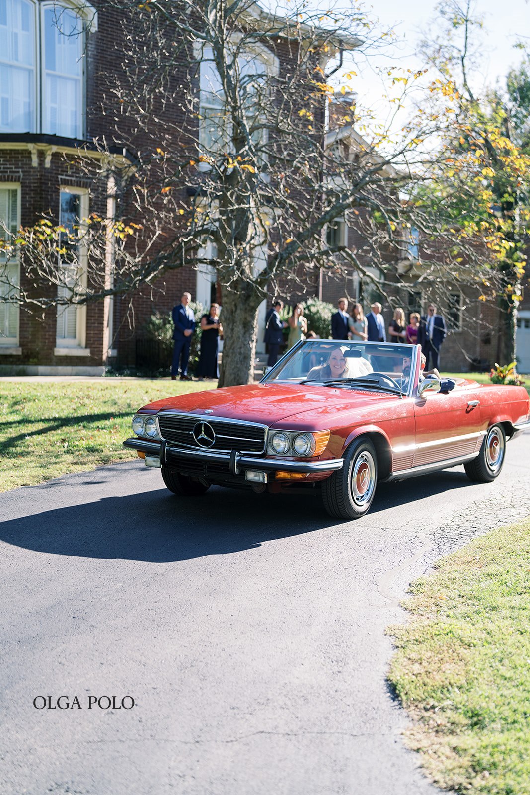 Ryan and Beth standing with the vintage red Mercedes at Heartland of Versailles