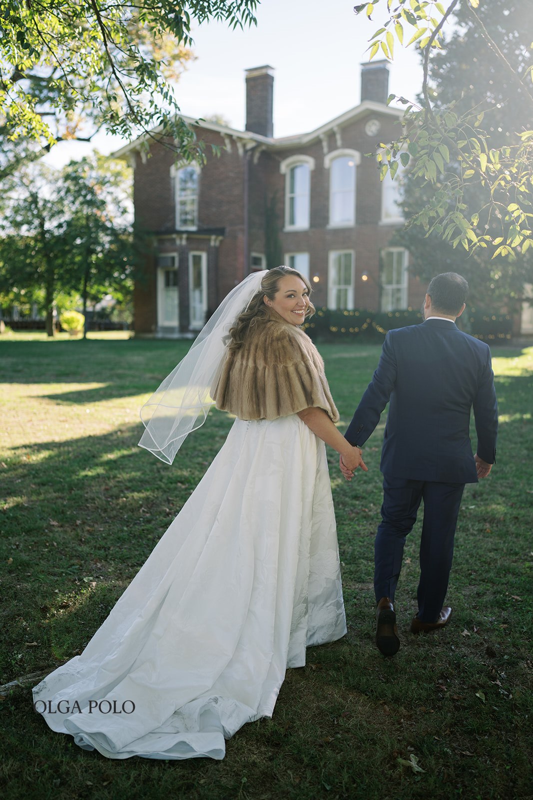 Ryan and Beth walking across the lawn in front of the Heartland of Versailles house