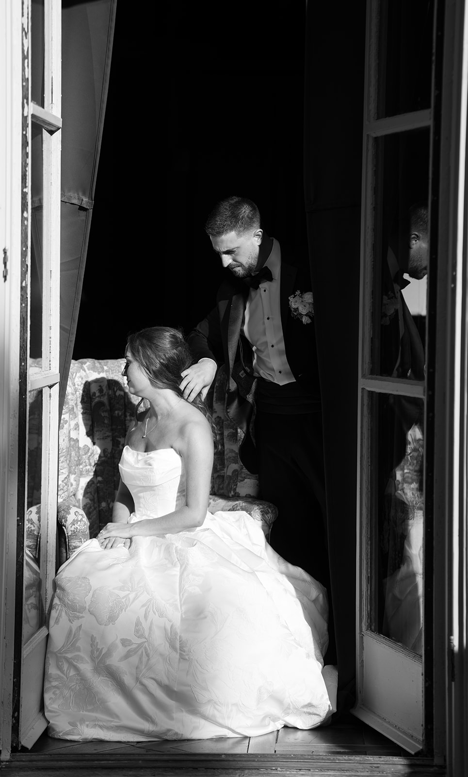 Black-and-white bridal portrait of Olivia in a bedroom by a window